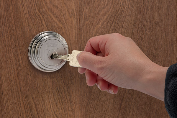 Hand holding key unlocking door